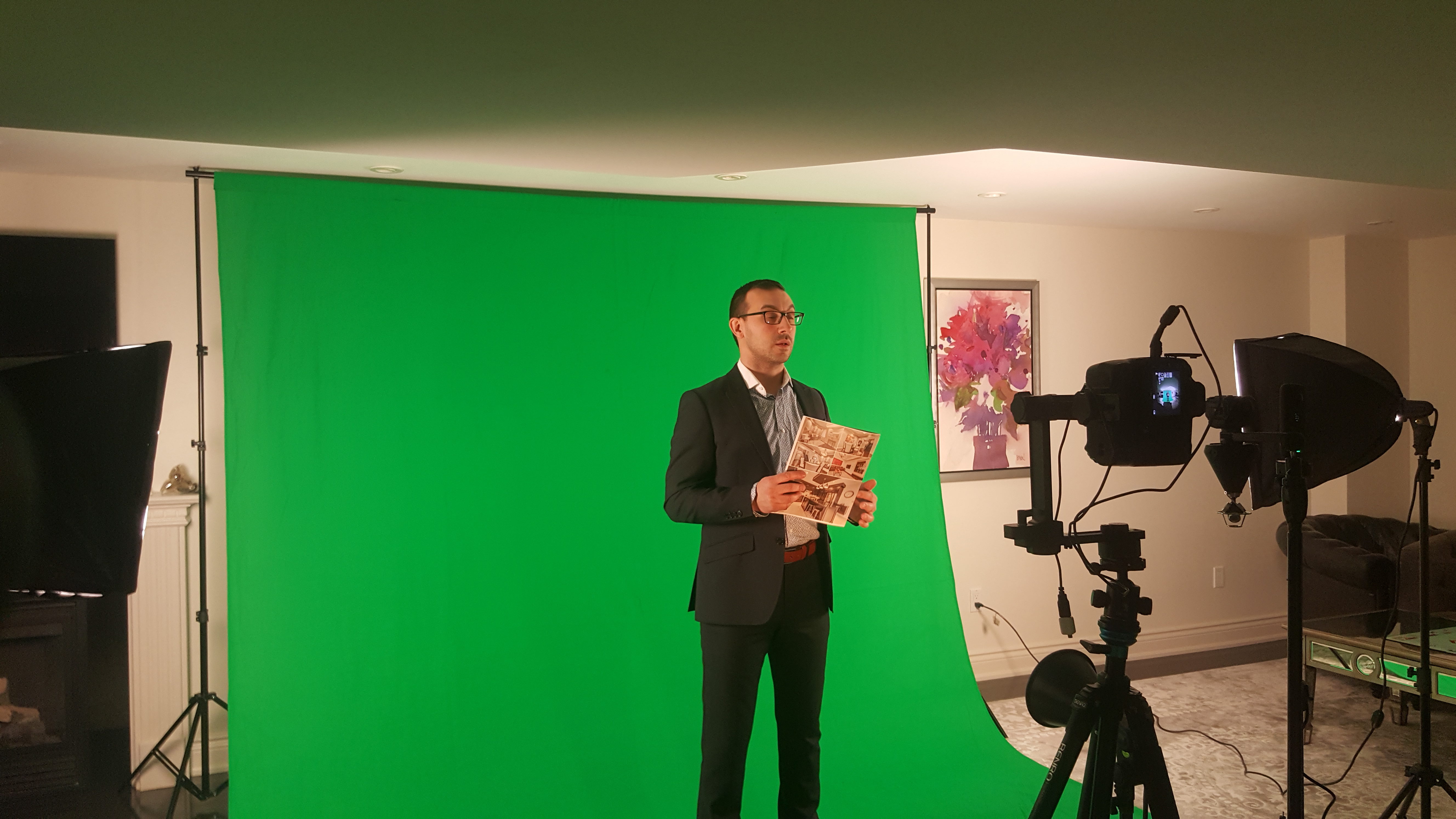 Man in formal wear being recorded in front of a green screen